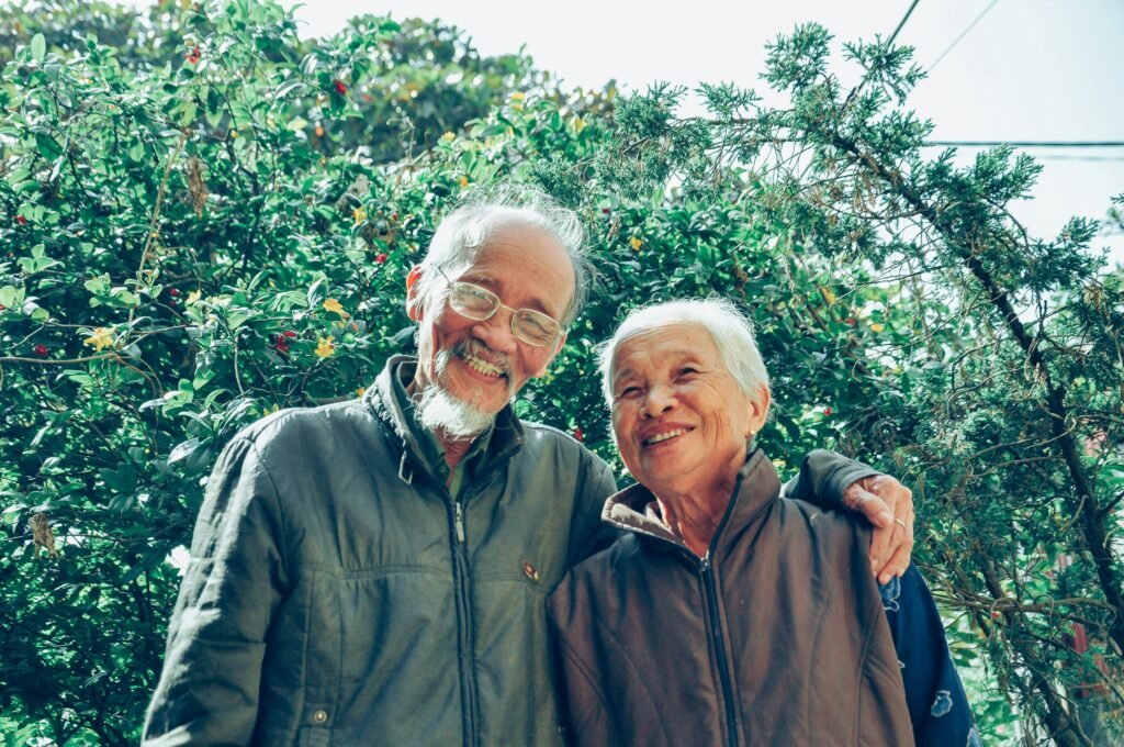 pexels-photo-1642883-1642883 Senior couple enjoying a joyful moment together in a lush garden setting, exuding love and happiness.